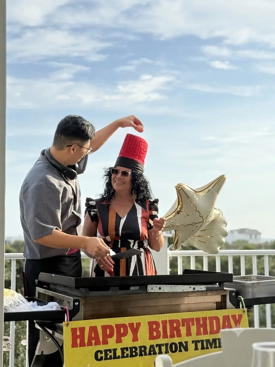 Private hibachi chef entertaining a guest on a sunny outdoor deck